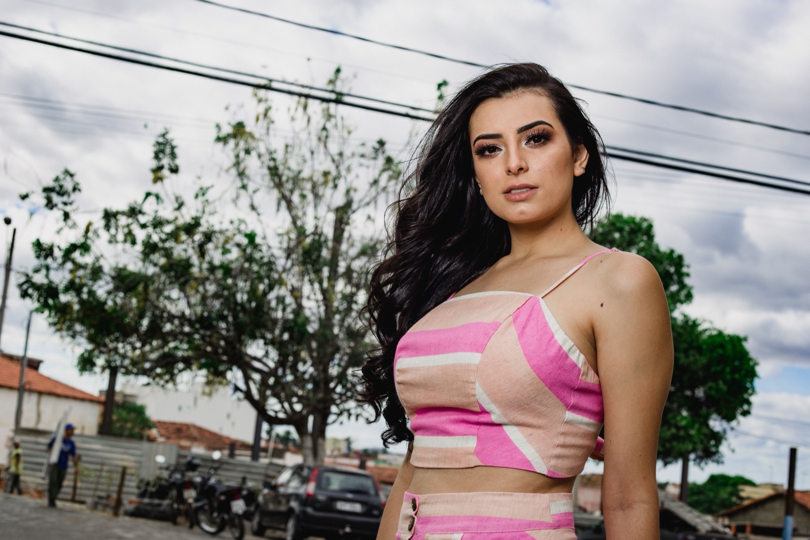 Woman posing outdoors against an urban backdrop